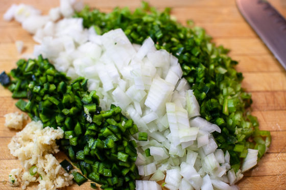 diced garlic, poblano, white onion, jalapeno, celery on cutting board