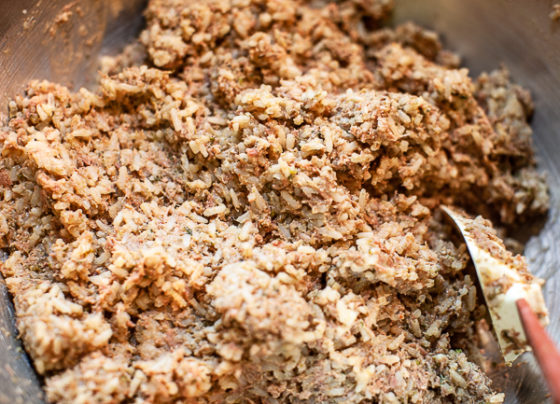 meat mixture and rice combined in bowl with rubber spatula