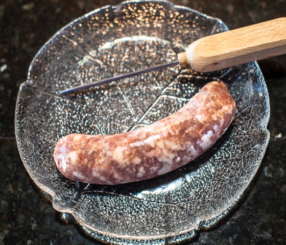 sausage on plate with ice pick or sausage pricker