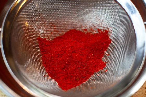 chile powder in mesh strainer