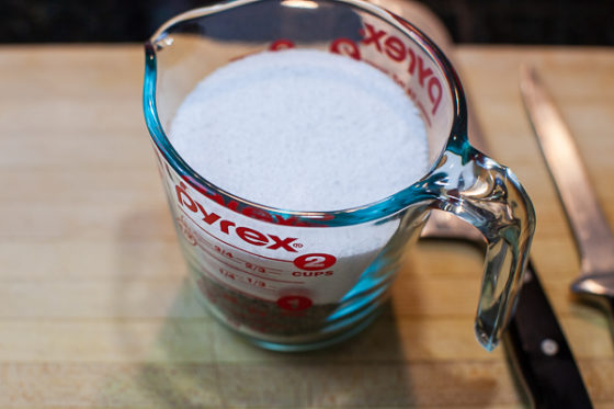 glass measuring cup containing kosher salt