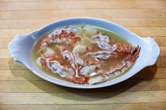 butterflied shrimp marinating in white dish with lime juice