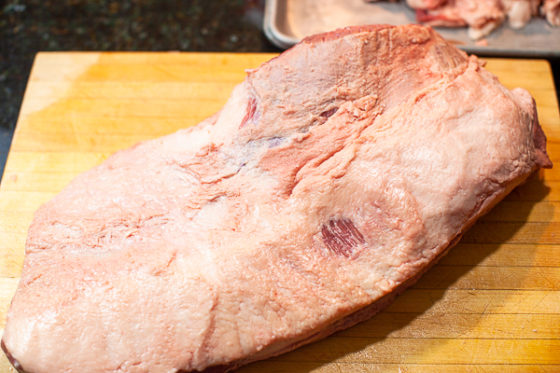 fully trimmed uncooked brisket fat side up on wooden cutting board