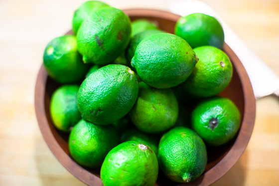 wooden bowl full of green limes