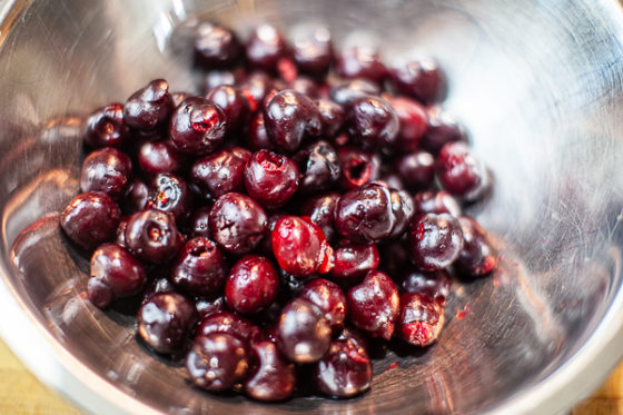 Pitted cherries in metal mixing bowl