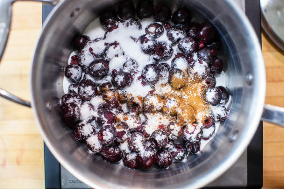 cherries in sauce pot covered with sugar, sinnamon, salt
