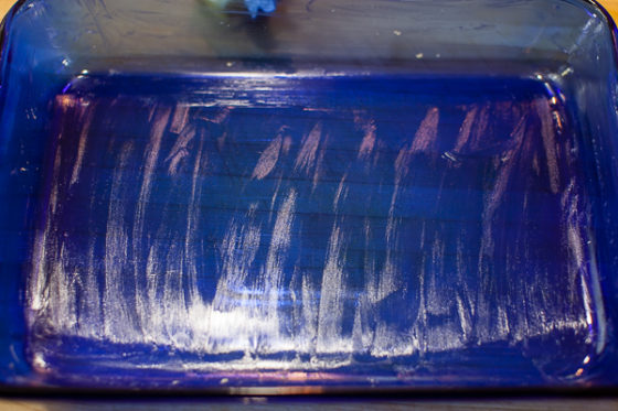 buttered baking dish on cutting board