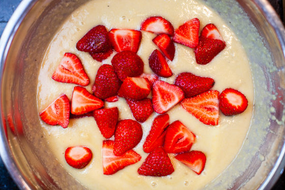 strawberries added to batter in metal mixing bowl