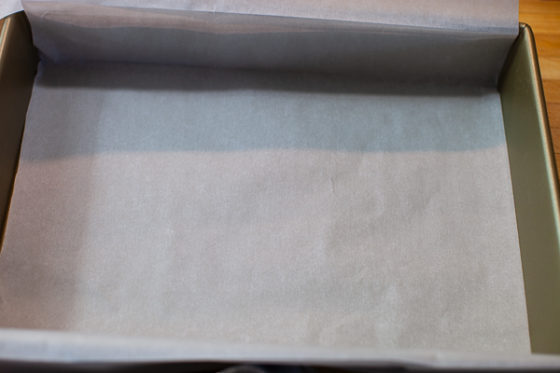 baking pan containing folded parchment over length edge