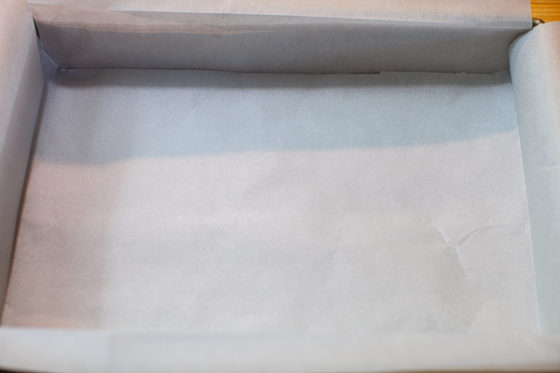 two pieces of parchment paper placed in bottom of baking pan, folded over edges