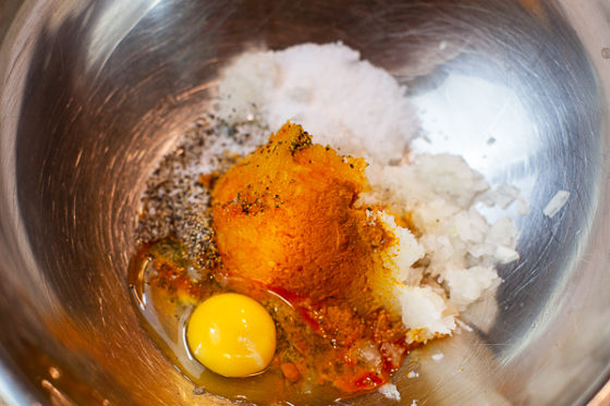 minced onion, salt, papper, turmeric, saffron water and egg in metal mixing bowl
