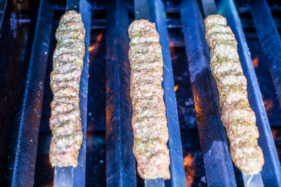 three kebabs placed over medium-hot flame cooking