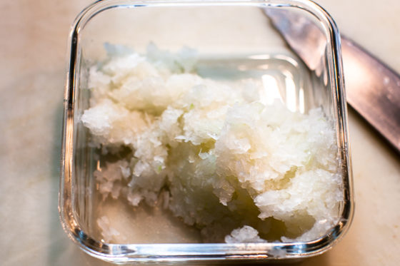 finely minced onion in square glass storage container