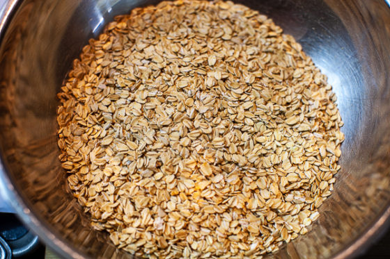 metal mixing bowl containing rolled oats