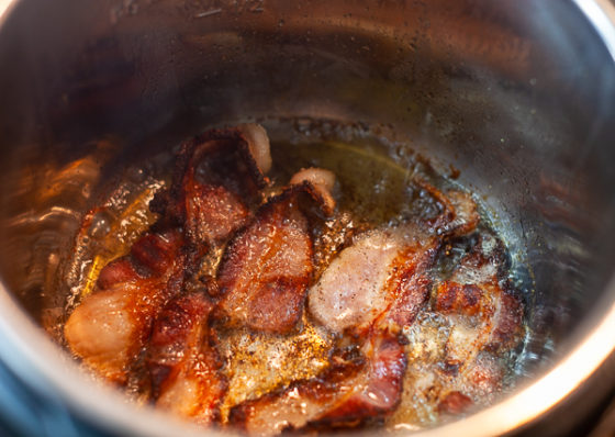 Cooked bacon in the bottom of a pot.