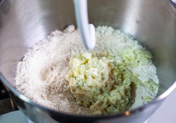 mixing bowl with bread flour and mixture of egg, yeast, cream cheese, dill and onion