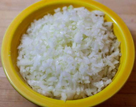 large yellow bowl full of minced onions